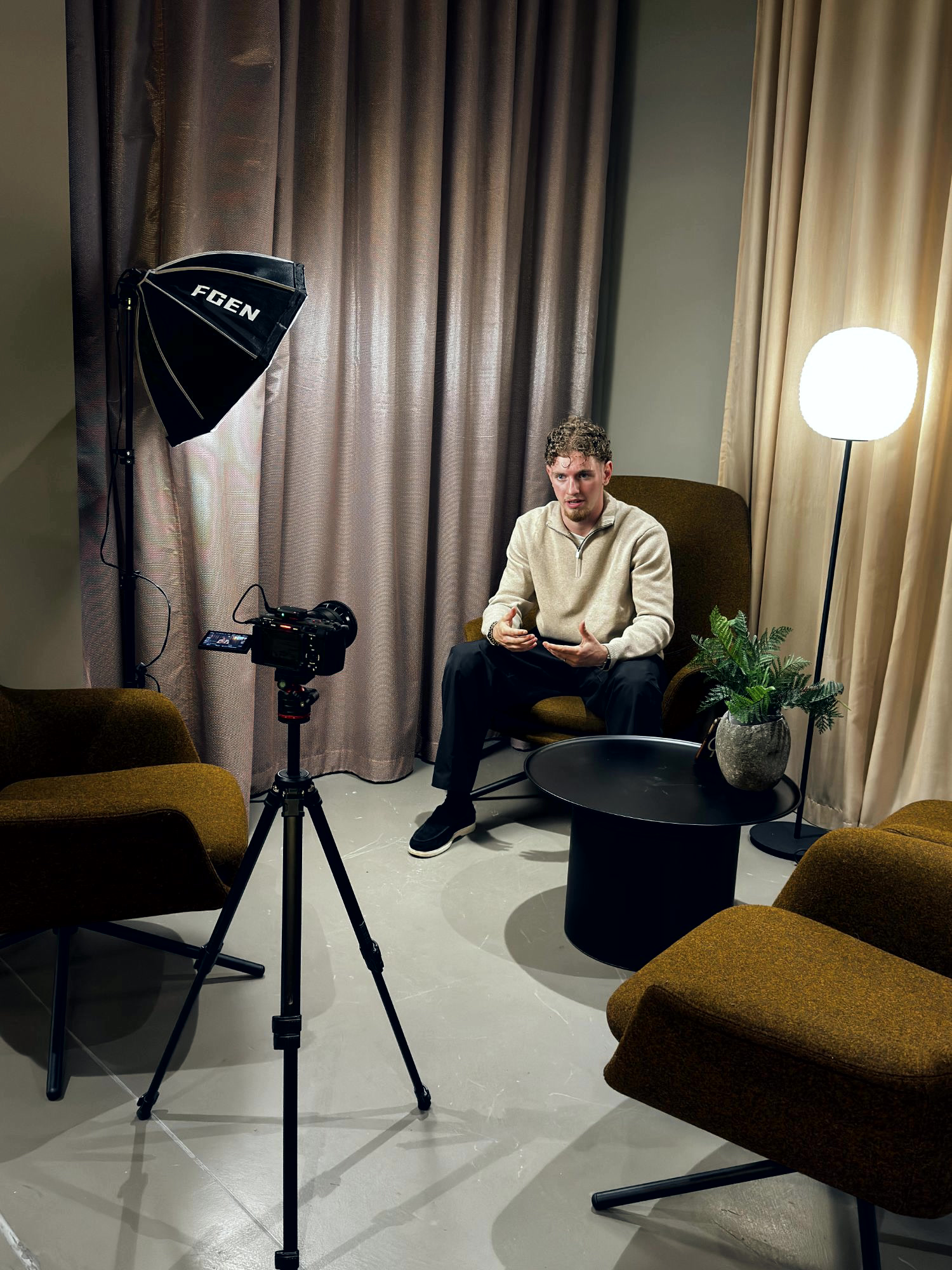 A NOVAA shoot in progress: camera on a tripod, softbox lighting and a subject mid-interview.
